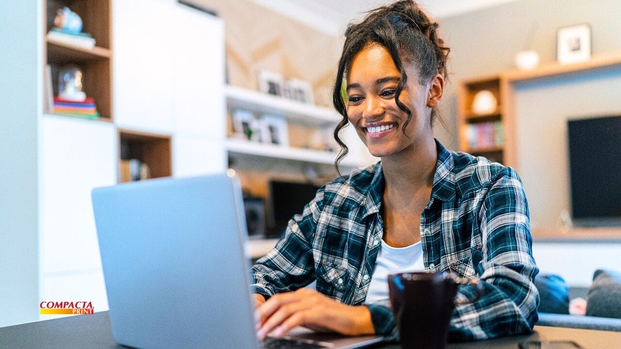 Mulher sorrindo em seu home office, planejando seu novo negócio para empreender em casa em 2026.