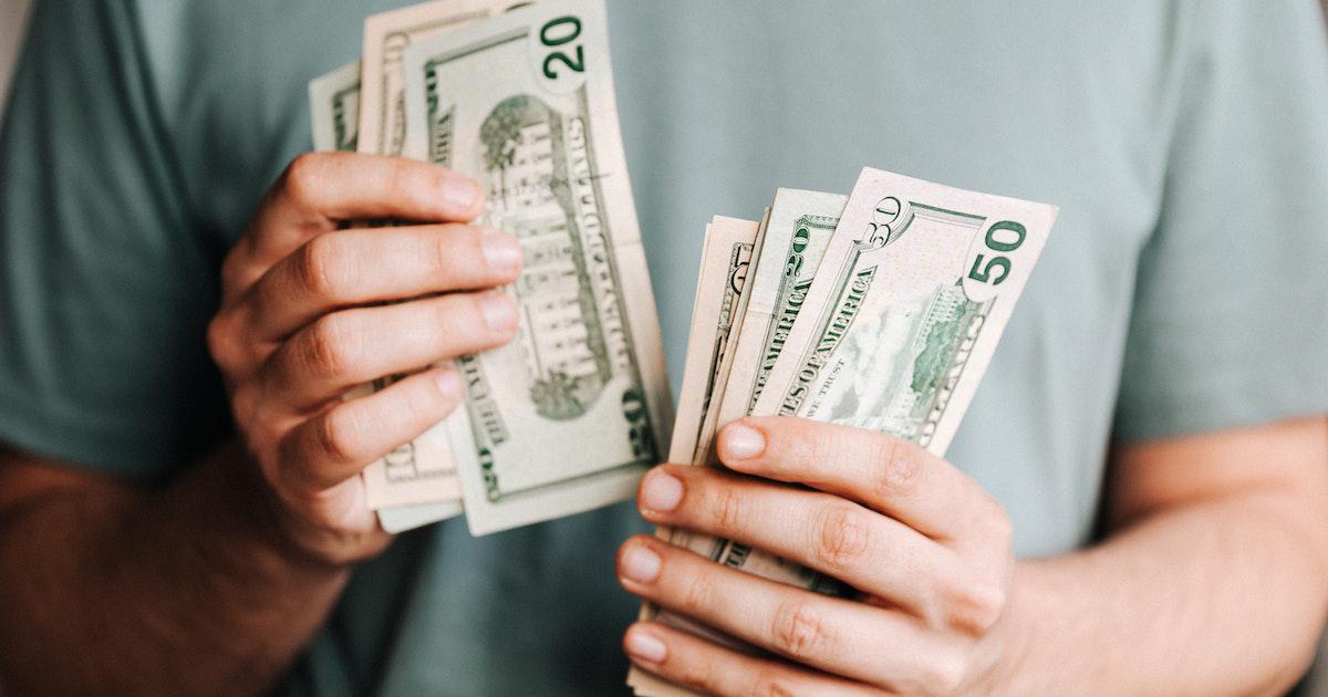 Renda Extra em Dólar: Os 10 Melhores Sites que Pagam via PayPal 4 um homem segurando notas de dólares ganhado online via paypal